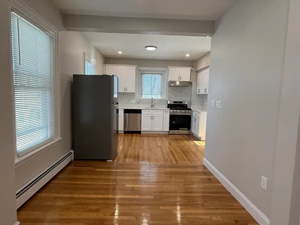 a kitchen with a refrigerator and a stove top oven