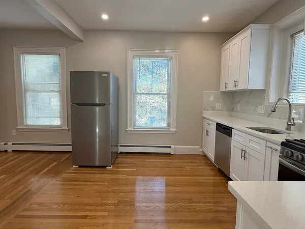a kitchen with a refrigerator a stove top oven and cabinets
