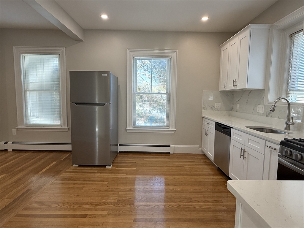 6 Channing Street, Unit 2 Newton, MA 02458 - Photo 3 of 17 a kitchen with a refrigerator a stove top oven and cabinets