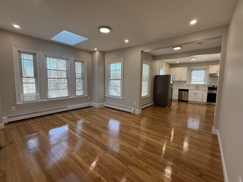 6 Channing Street, Unit 2 Newton, MA 02458 - Photo 5 of 17 a view of a living room with kitchen island granite countertop wooden floor and a large window