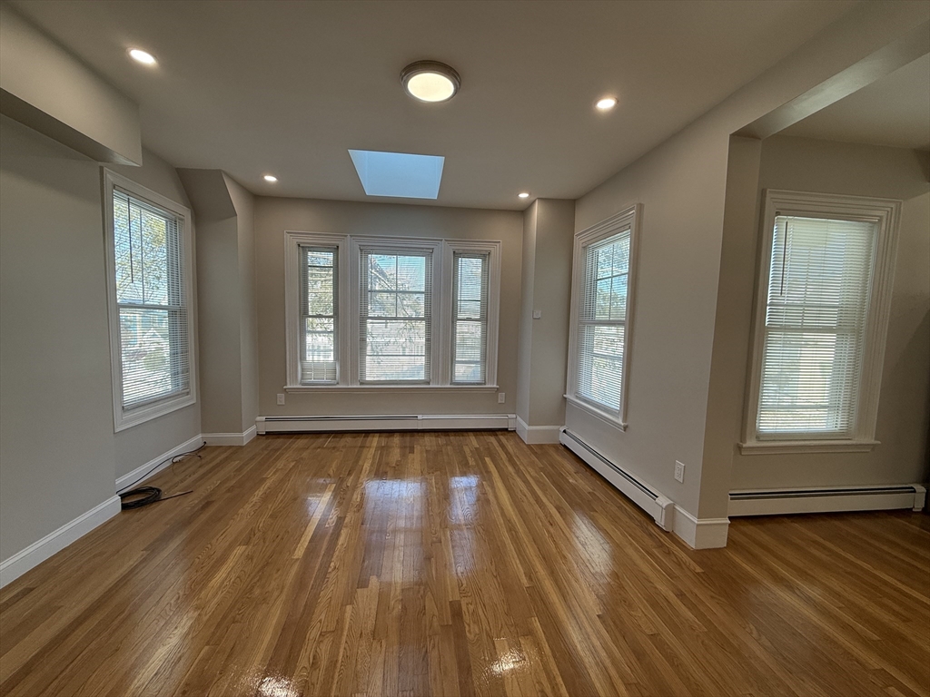 6 Channing Street, Unit 2 Newton, MA 02458 - Photo 7 of 17 an empty room with wooden floor and windows