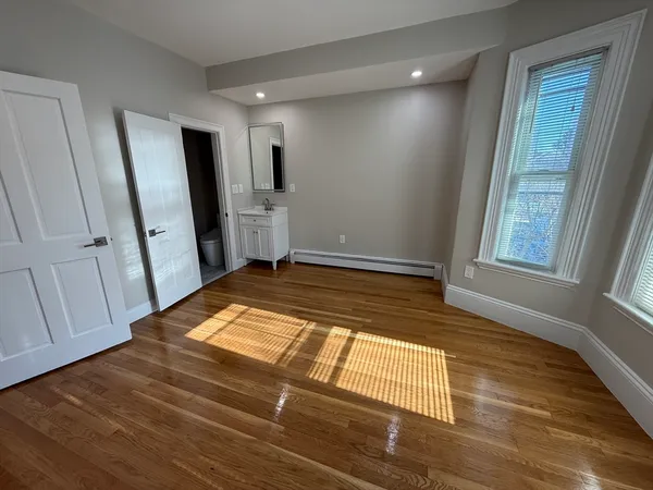a view of empty room with wooden floor