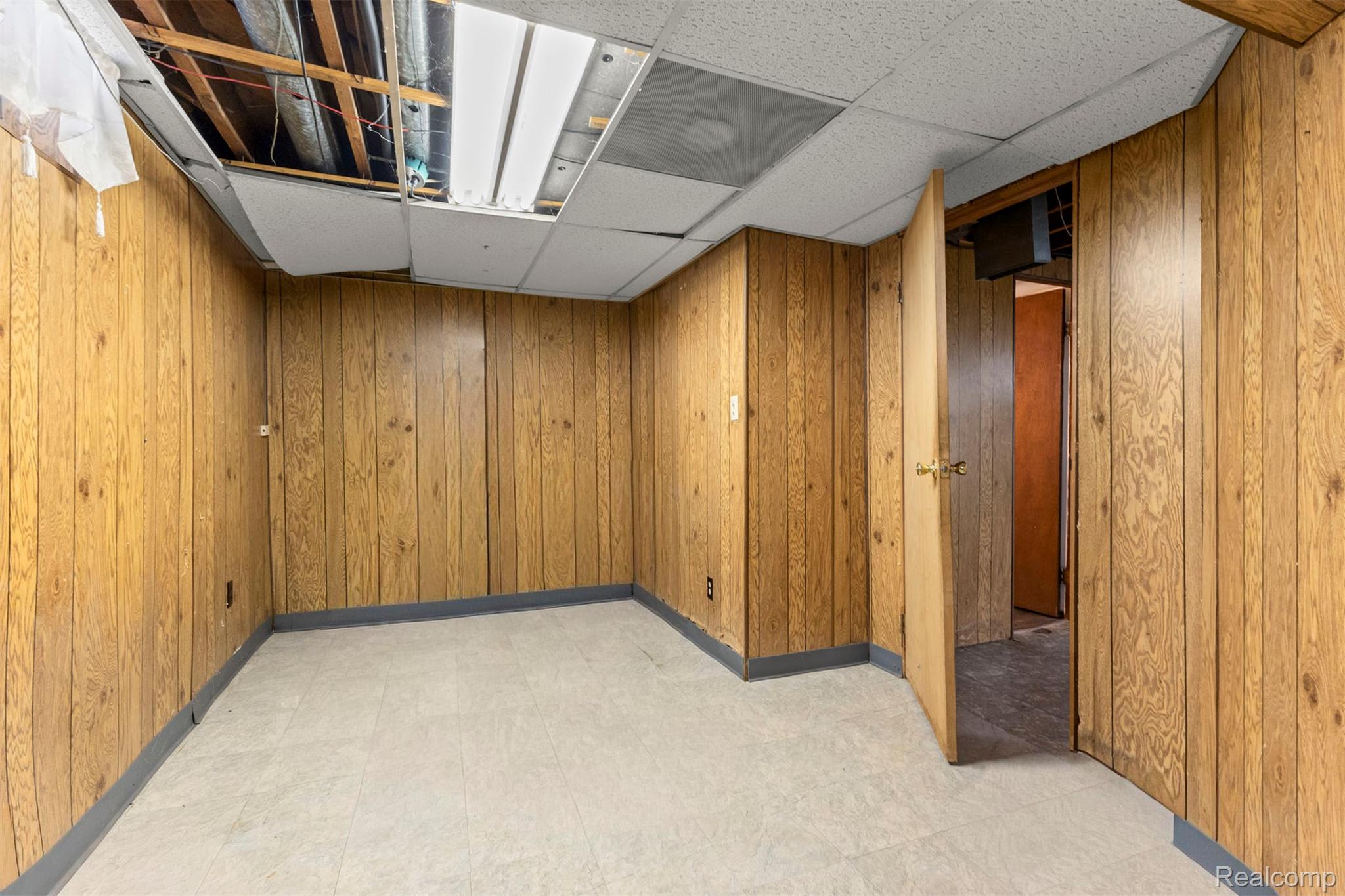 14716 Eureka Road Southgate, MI 48195 - Photo 35 of 42 Unfurnished room featuring a drop ceiling, light floors, and wood walls