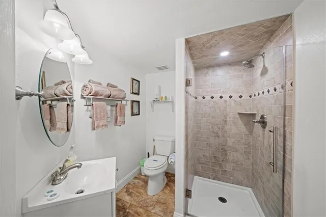 a bathroom with a granite countertop shower and a toilet