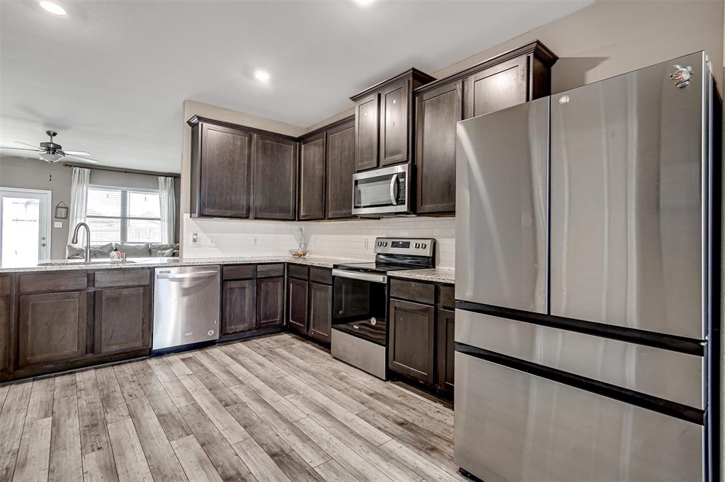 1813 Rialto Lane Crowley, TX 76036 - Photo 8 of 27 a kitchen with granite countertop a refrigerator stove and sink