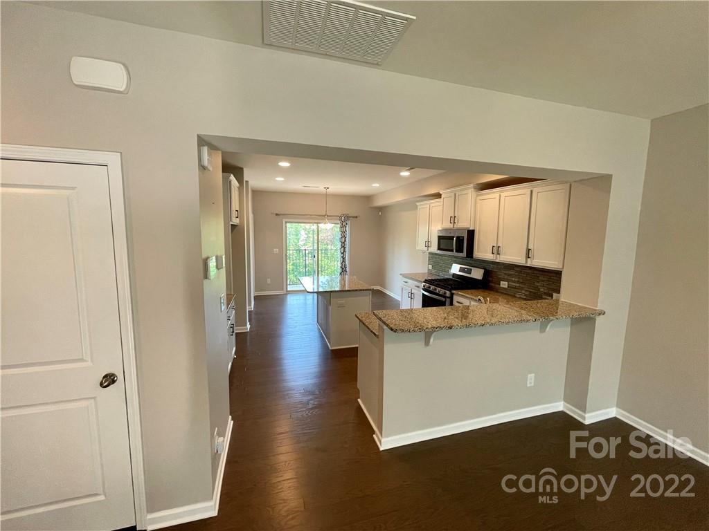 715 Swift Run Tega Cay, SC 29708 - Photo 4 of 24 a living room with stainless steel appliances kitchen island hardwood floor and a view of kitchen