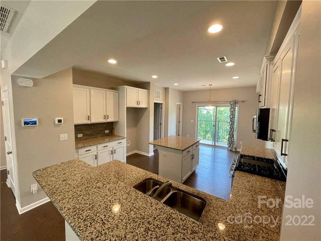 715 Swift Run Tega Cay, SC 29708 - Photo 5 of 24 a large kitchen with stainless steel appliances kitchen island granite countertop a refrigerator and a sink