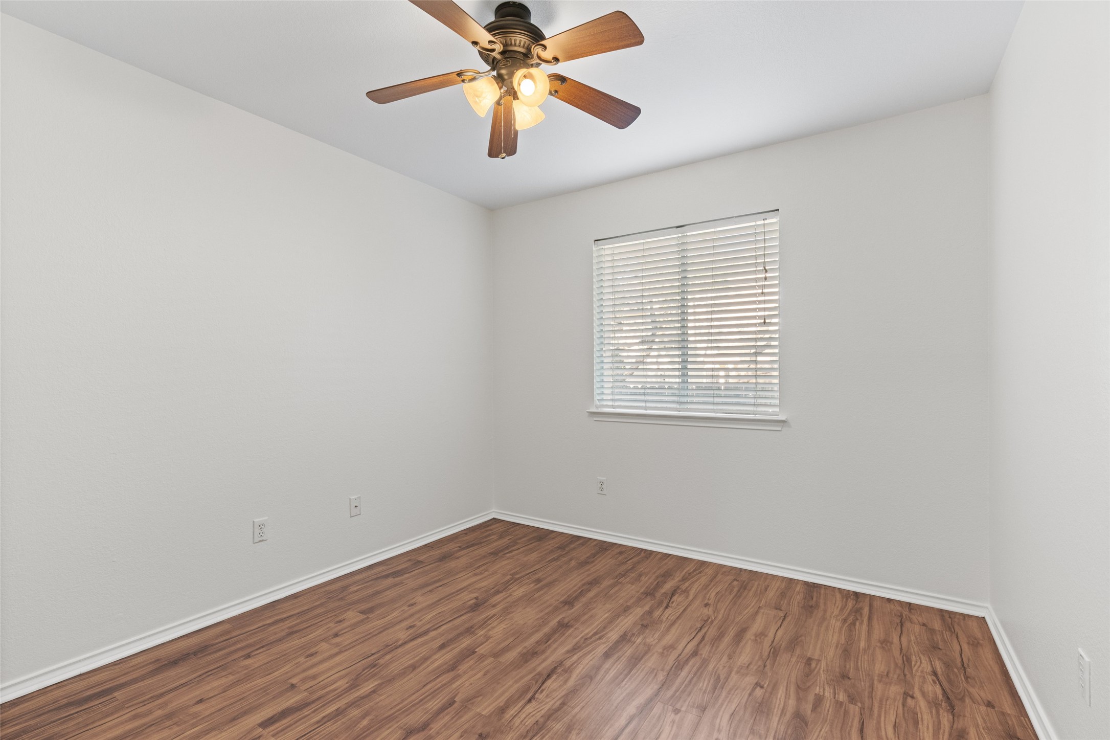 8430 Alvin High Lane Austin, TX 78729 - Photo 18 of 31 an empty room with wooden floor chandelier fan and windows