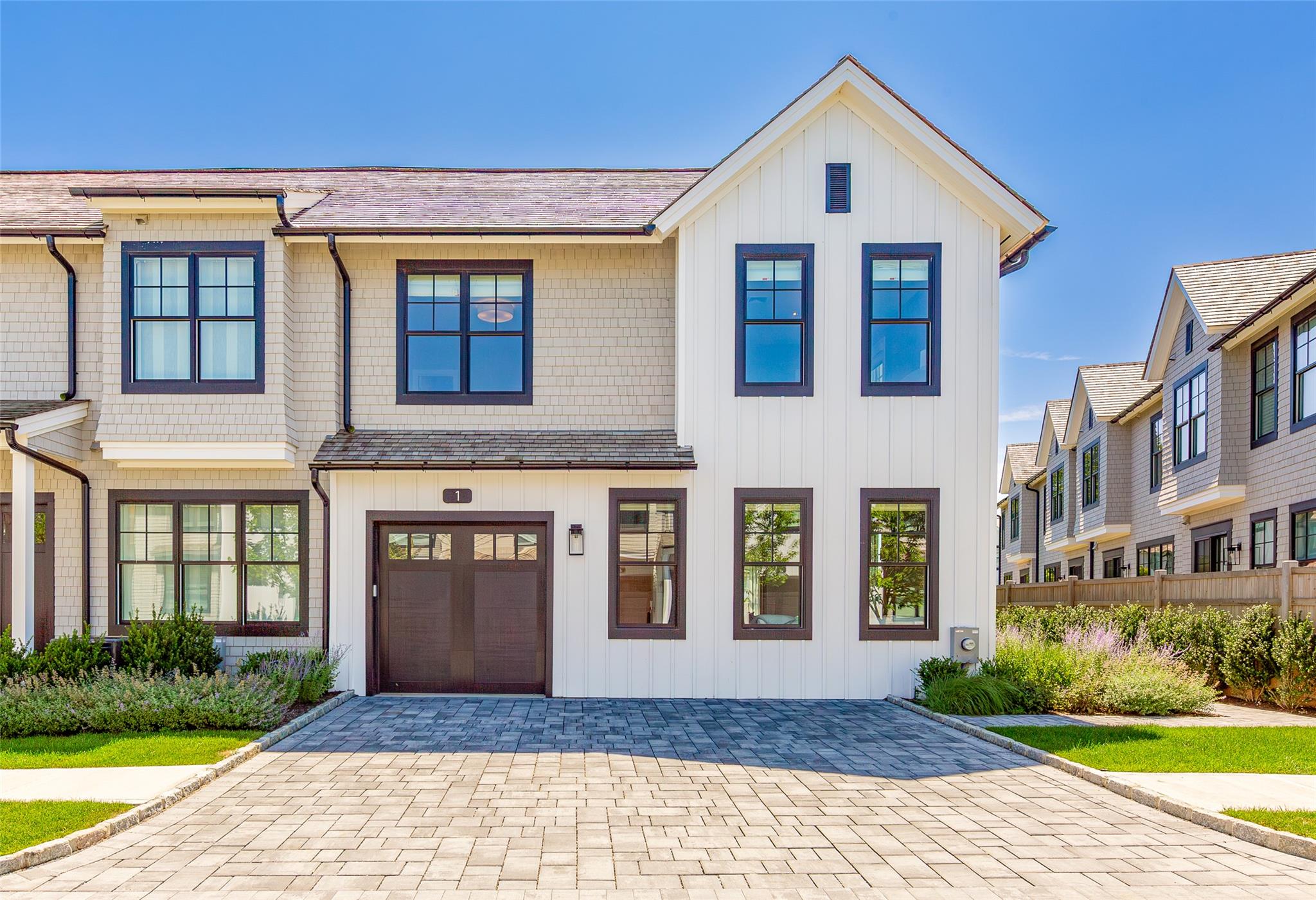 View of front facade with decorative driveway and board and batten siding