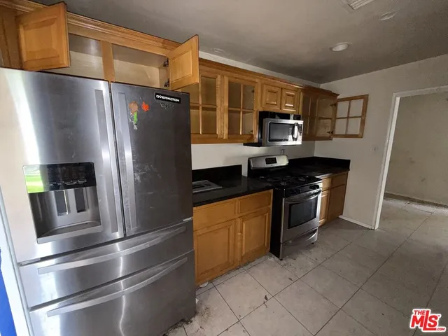 a kitchen with stainless steel appliances and refrigerator