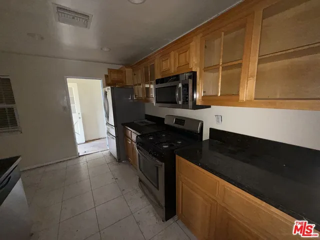 a kitchen with stainless steel appliances a stove a microwave a sink and cabinets
