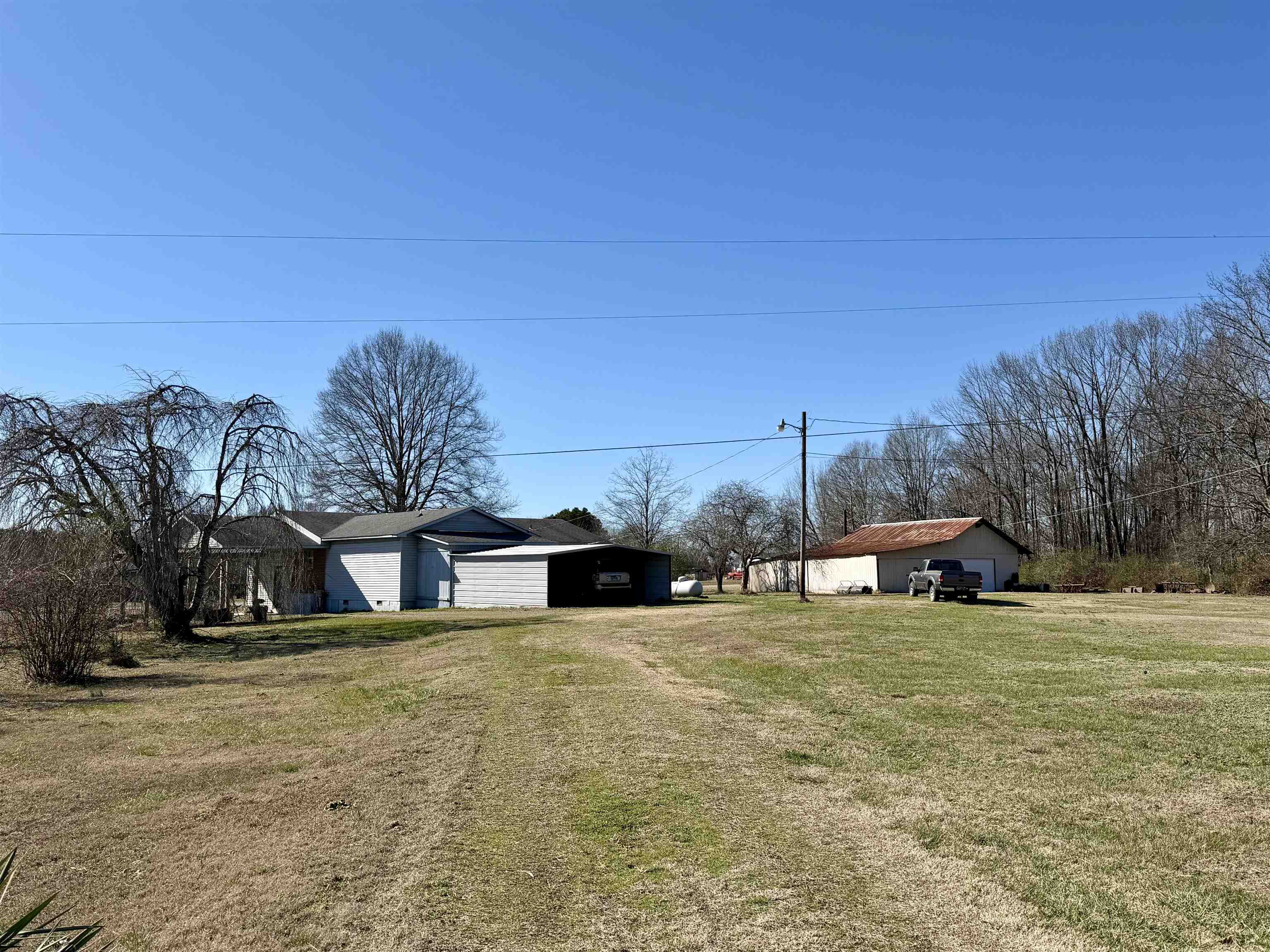 254 Michie Road Michie, TN 38357 - Photo 15 of 16 View of grassy yard with a carport, driveway, and an outdoor structure