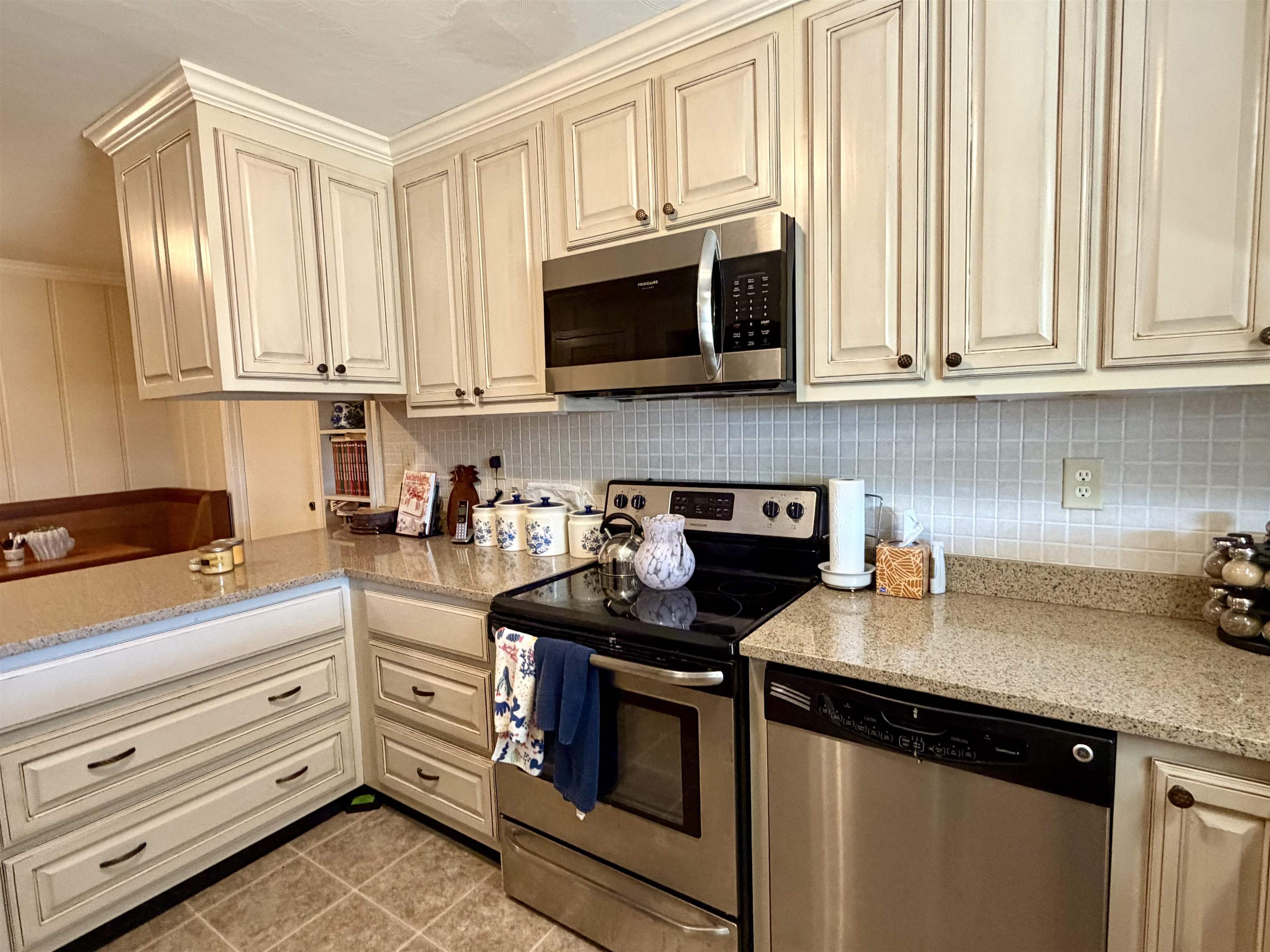 254 Michie Road Michie, TN 38357 - Photo 3 of 16 Kitchen with cream cabinets, stainless steel appliances, light stone counters, light tile patterned floors, and ornamental molding