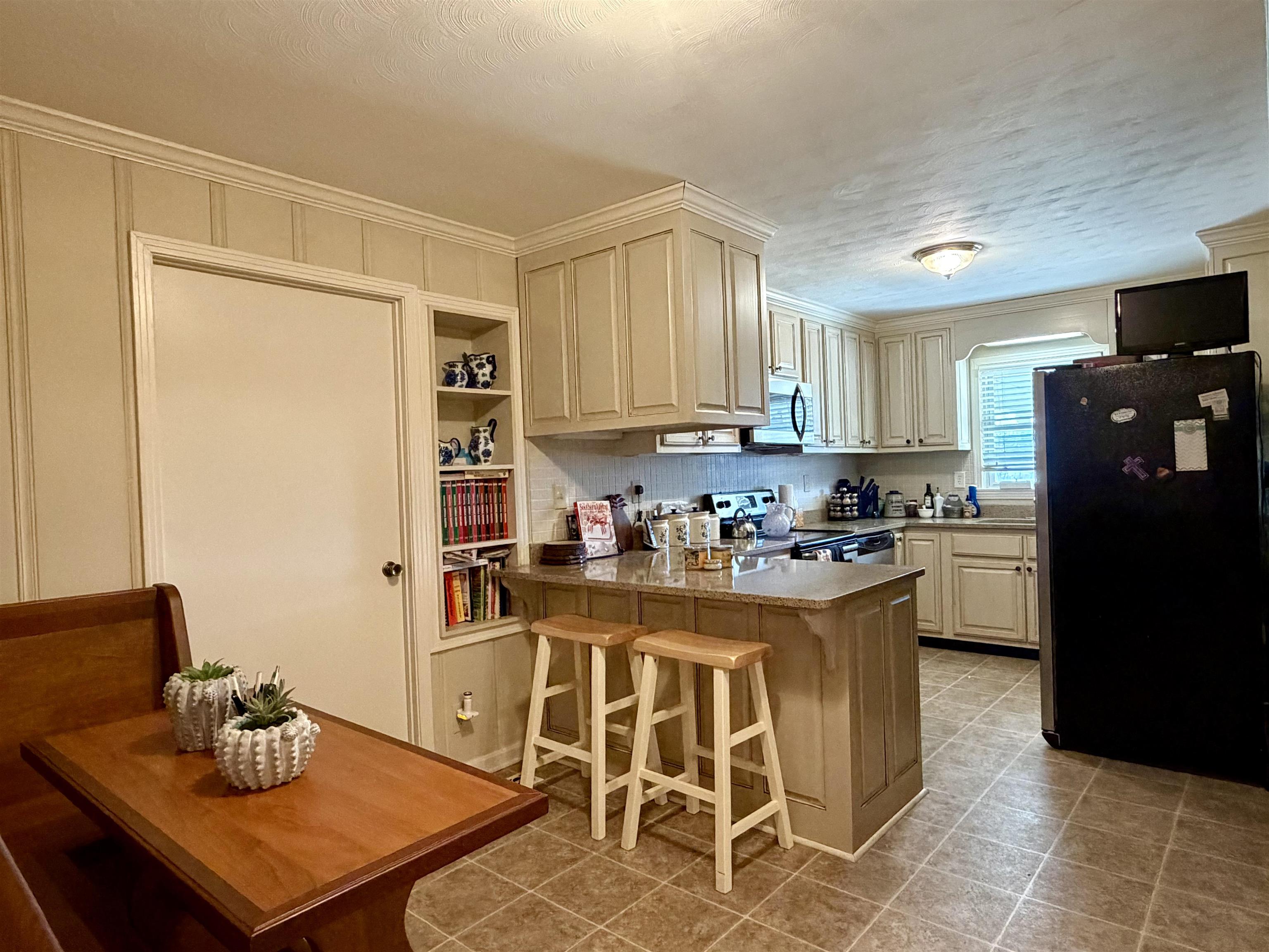 254 Michie Road Michie, TN 38357 - Photo 7 of 16 Kitchen with stainless steel appliances, a peninsula, a breakfast bar area, a textured ceiling, and light countertops