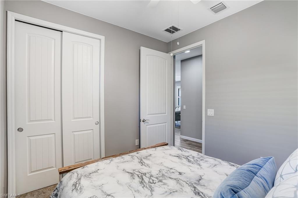 20308 Corkscrew Shores Boulevard Estero, FL 33928 - Photo 22 of 47 Bedroom with a closet, a ceiling fan, and baseboards