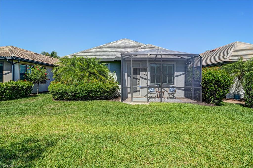 20308 Corkscrew Shores Boulevard Estero, FL 33928 - Photo 27 of 47 Rear view of house featuring a patio area, a yard, a lanai, and stucco siding