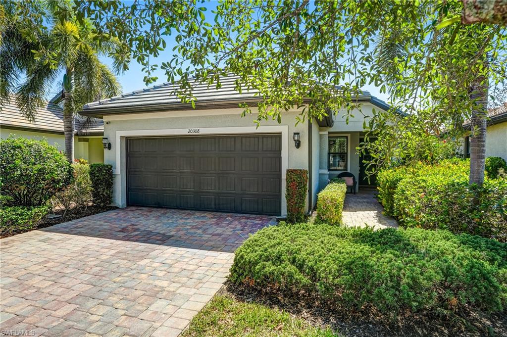 20308 Corkscrew Shores Boulevard Estero, FL 33928 - Photo 29 of 47 View of front facade with stucco siding, an attached garage, and driveway