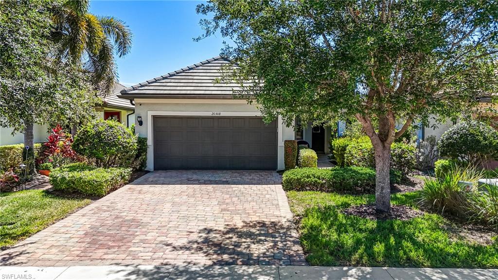 20308 Corkscrew Shores Boulevard Estero, FL 33928 - Photo 30 of 47 View of front of property with decorative driveway, stucco siding, an attached garage, and a tiled roof