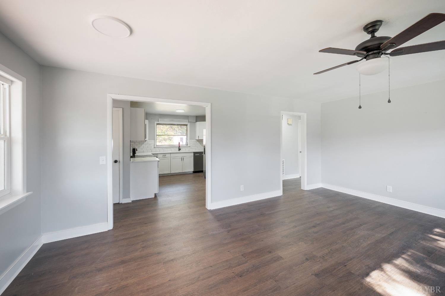 109 Hillside Road Hurt, VA 24563 - Photo 3 of 42 an empty room with wooden floor a ceiling fan and windows