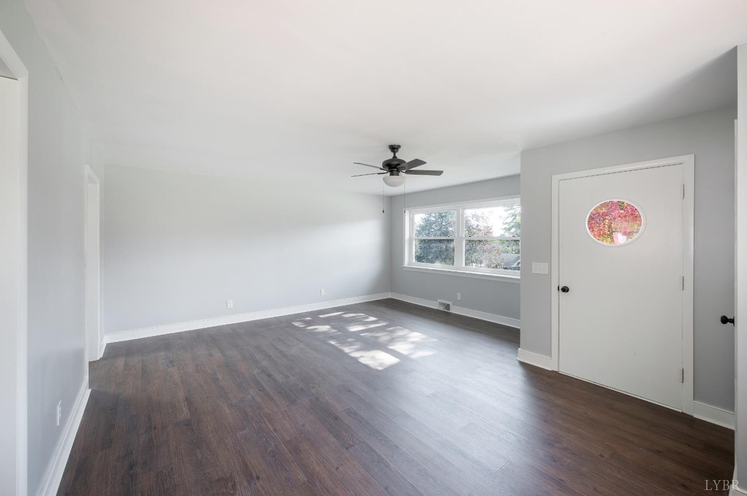 109 Hillside Road Hurt, VA 24563 - Photo 5 of 42 an empty room with wooden floor cabinet and windows