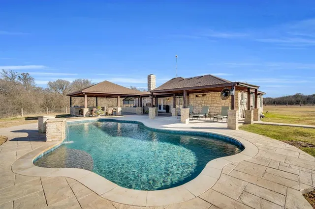 a view of a house with swimming pool and sitting area