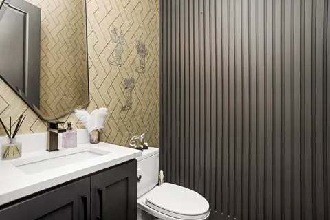 a bathroom with a granite countertop toilet sink and mirror