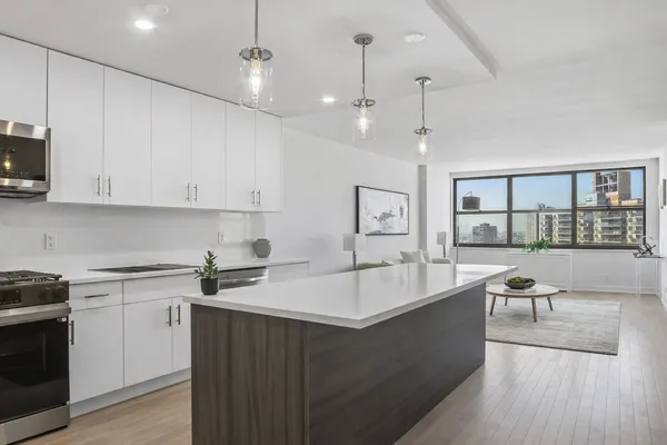 a large kitchen with stainless steel appliances granite countertop a sink a stove and a wooden floors