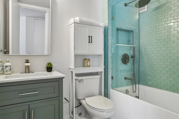 a bathroom with a sink a toilet and shower