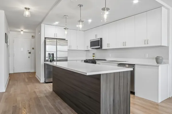 a kitchen with kitchen island a sink stainless steel appliances and cabinets