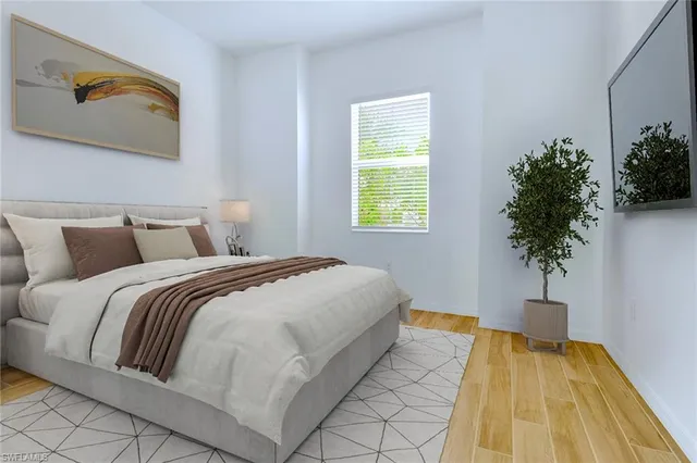 a bedroom with a bed and a potted plant