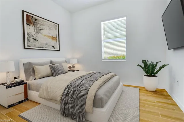 a spacious bedroom with bed and a potted plant