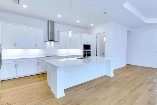 a kitchen with stainless steel appliances granite countertop a sink a stove and a wooden floors