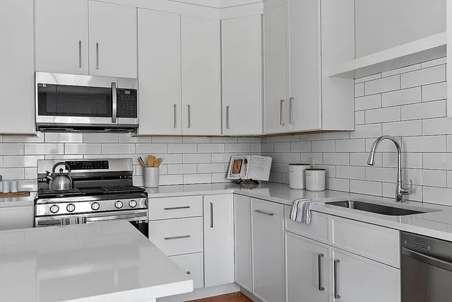 a kitchen with cabinets stainless steel appliances and a sink