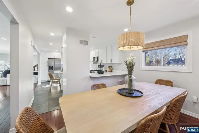 a dining room with chandelier and wooden floor
