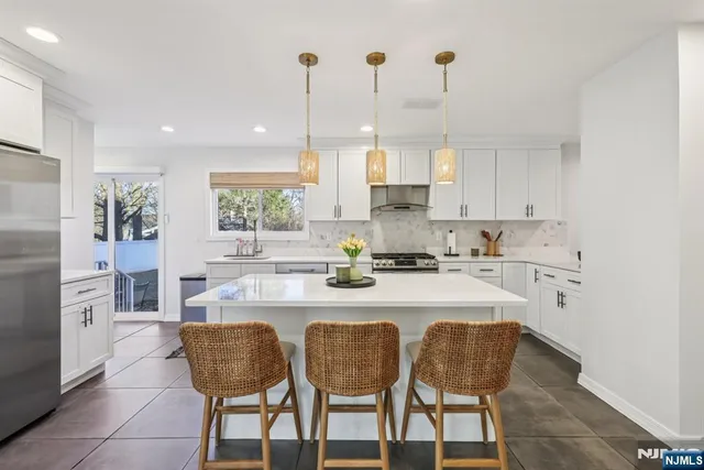 a kitchen with a dining table chairs cabinets and stainless steel appliances
