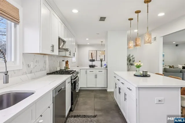a kitchen with white cabinets appliances and sink