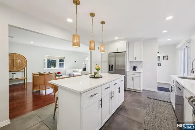 a kitchen with a stove a refrigerator and a dining table with wooden floor