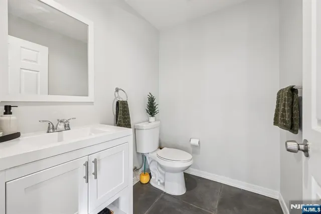 a bathroom with a granite countertop sink and a toilet