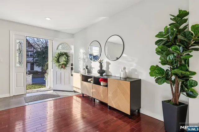 a living room with furniture a potted plant and a wooden floor