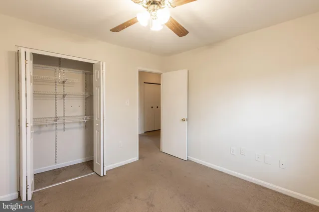 a view of an empty room and chandelier fan