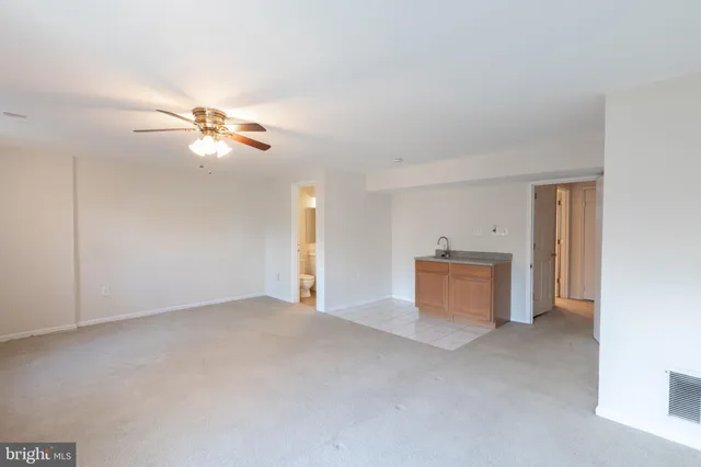 a view of an empty room with a chandelier fan