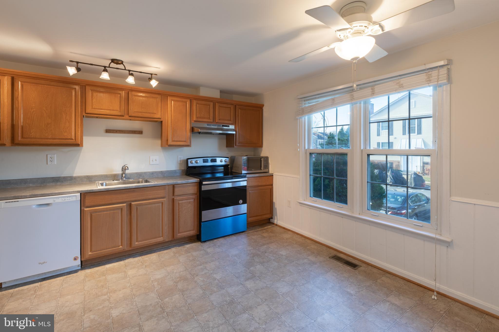 8132 Sleepy View Lane Springfield, VA 22153 - Photo 3 of 31 a kitchen with stainless steel appliances granite countertop a stove a sink dishwasher a refrigerator and a dining table with wooden floor