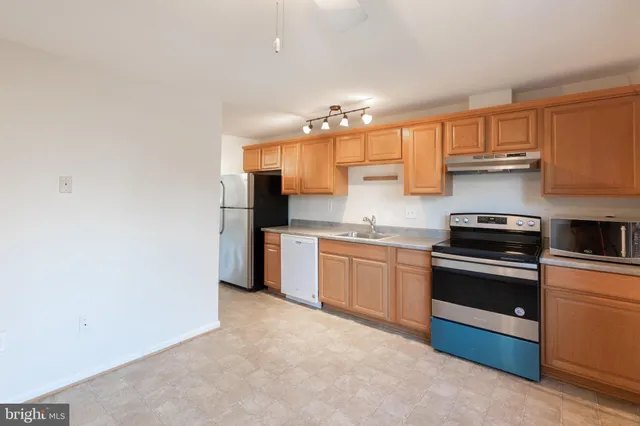 a kitchen with stainless steel appliances granite countertop a sink and a stove