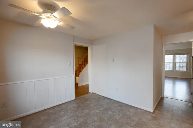 an empty room with closet and a chandelier fan