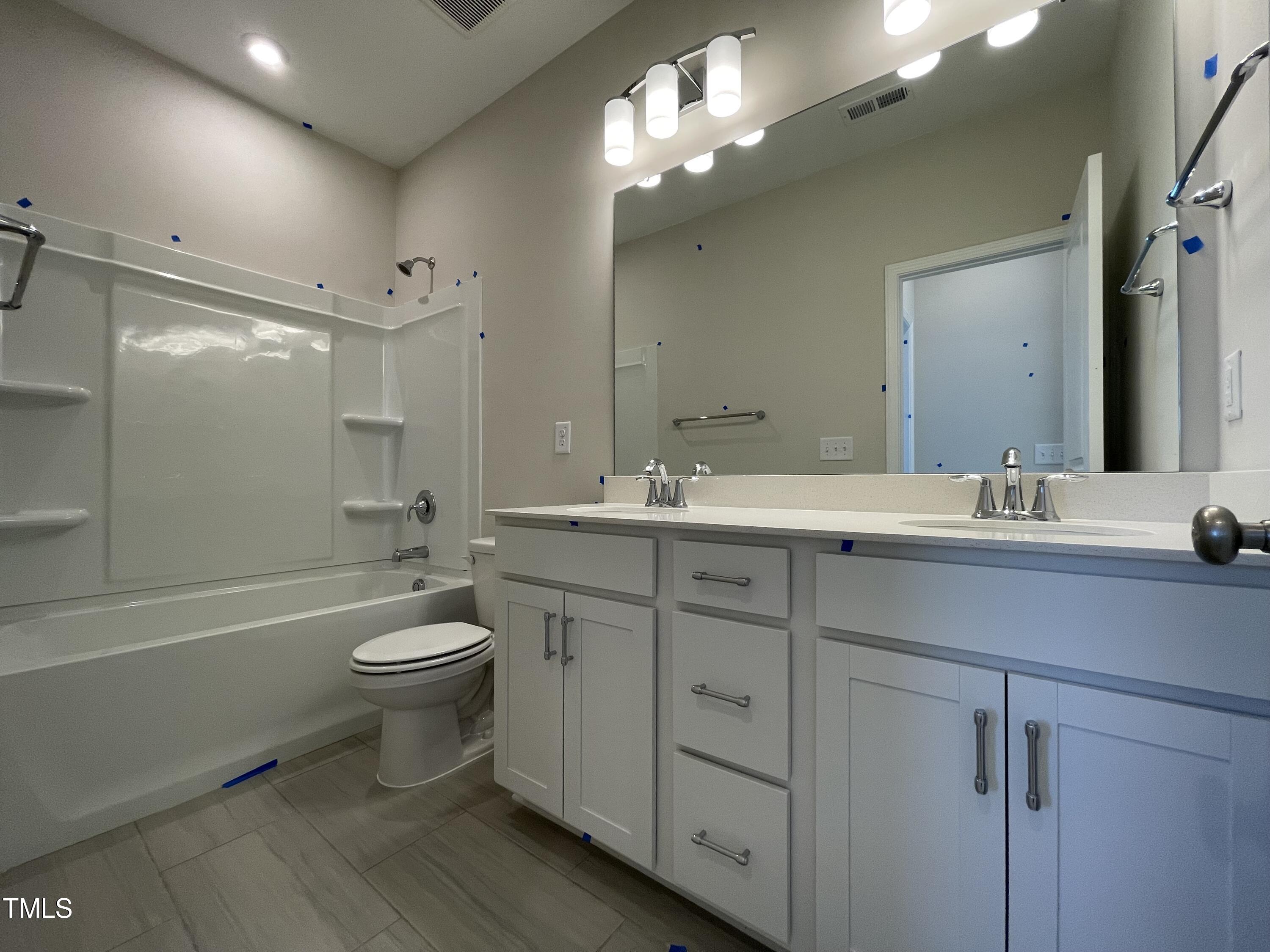 548 Marthas View Way Wake Forest, NC 27587 - Photo 32 of 44 a bathroom with a double vanity sink toilet a shower and a bathtub