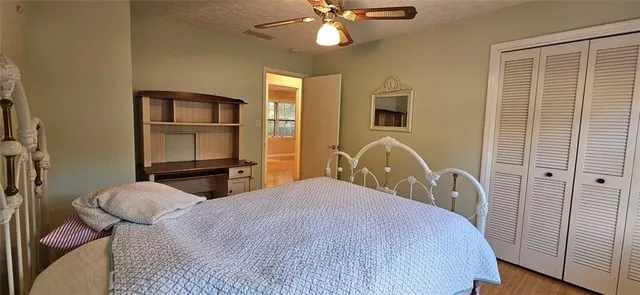 a bedroom with a bed and a dresser with wooden floor
