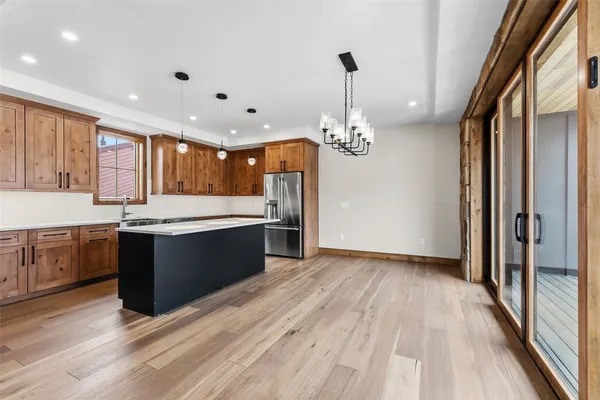 a large kitchen with kitchen island a large counter space wooden floor and stainless steel appliances