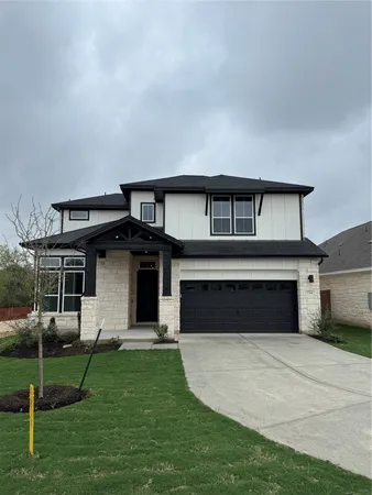 a front view of a house with a yard and a garage