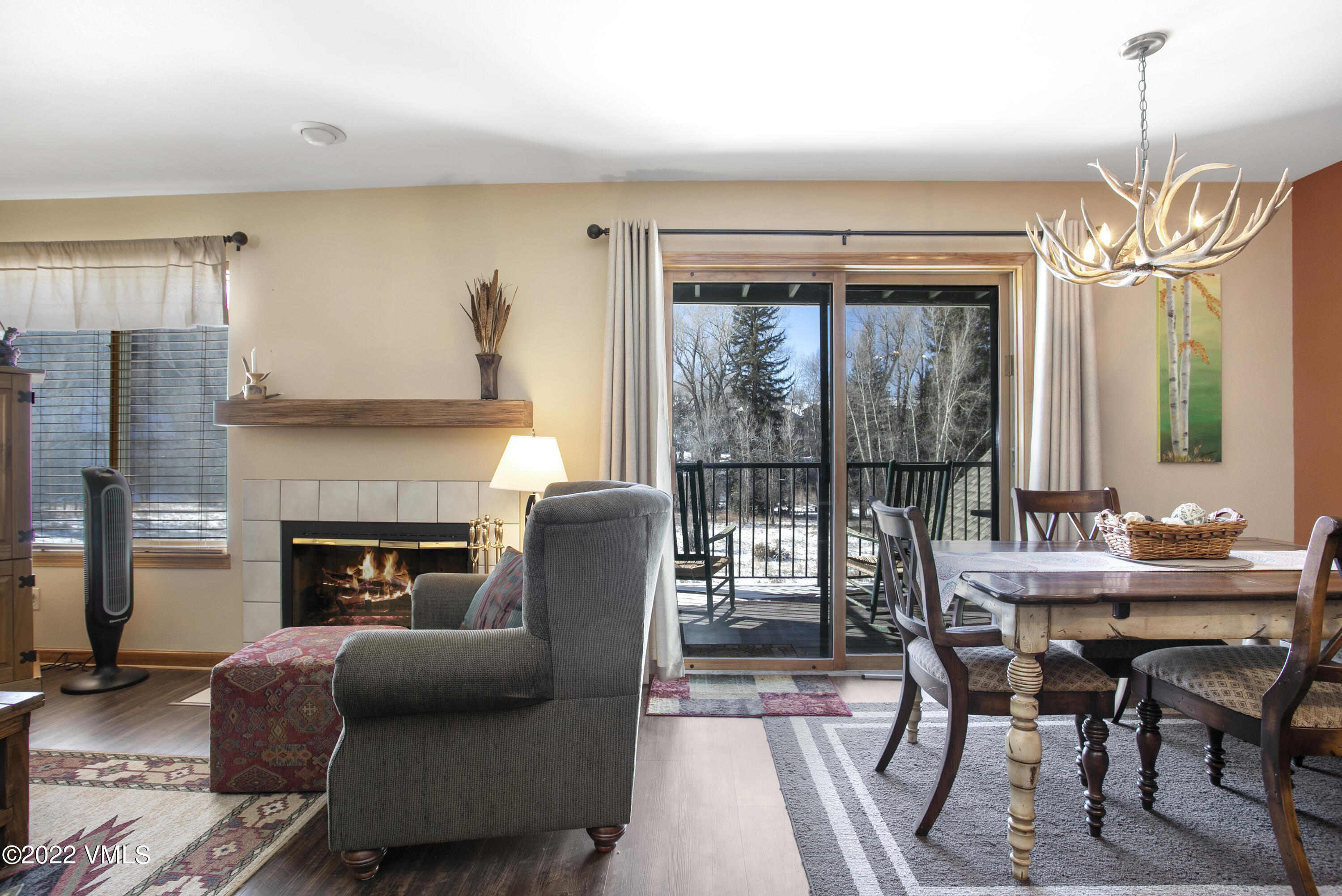 a living room with furniture a fireplace and a floor to ceiling window