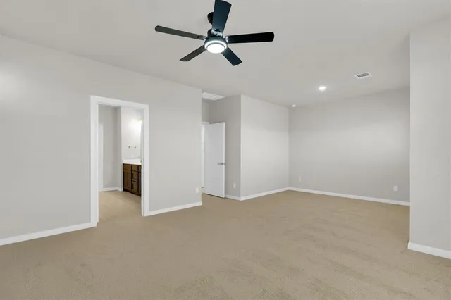 wooden floor in an empty room with a ceiling fan